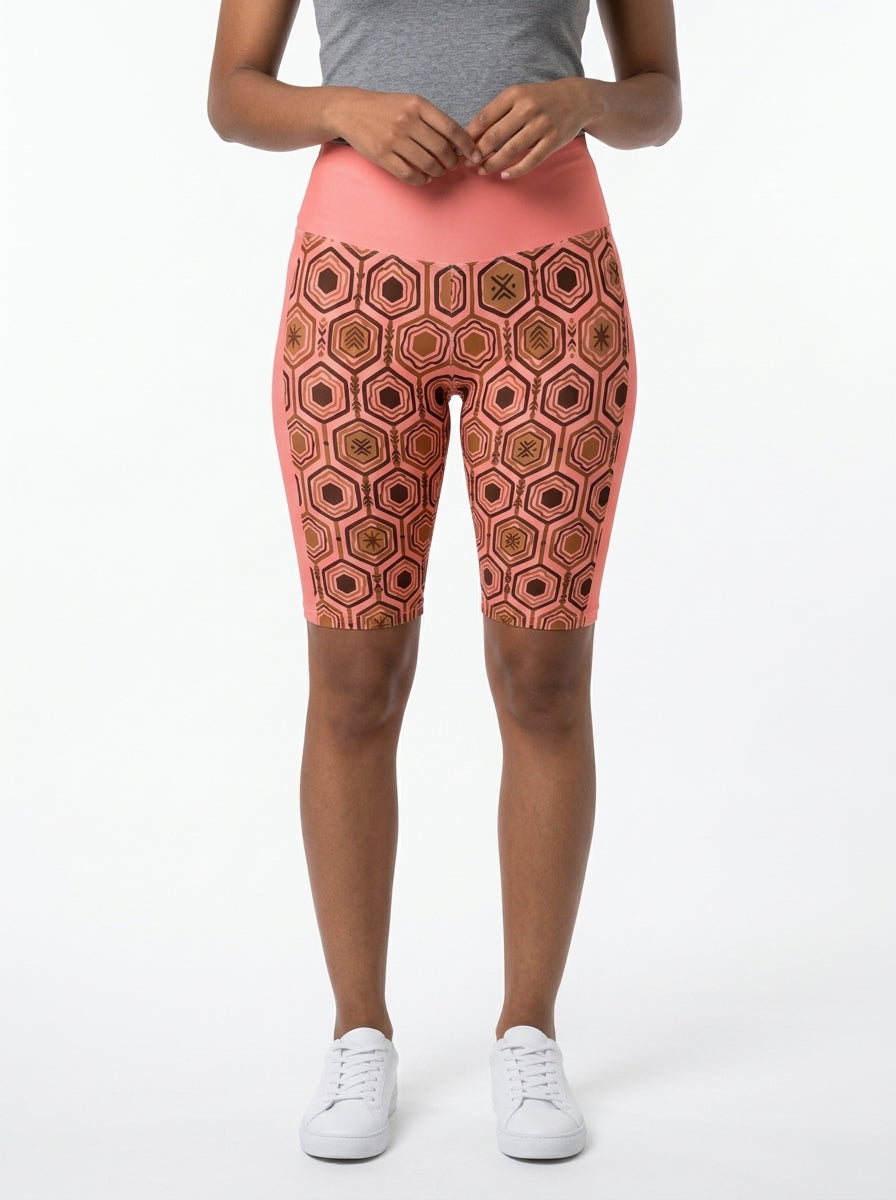 AnanseNova™ Biker Shorts in Adaeze Pink with hexagon web-cell print, studio front view — SunBorn
