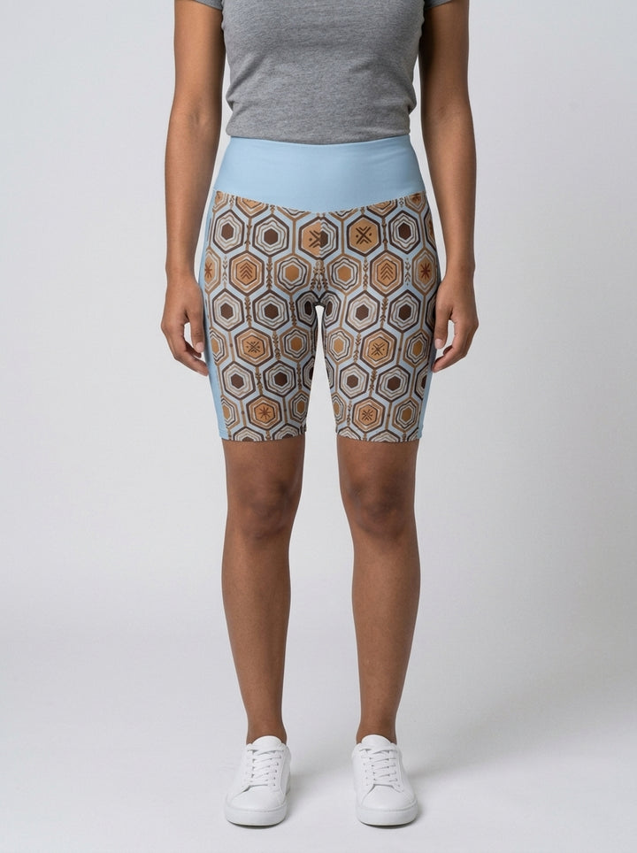 AnanseNova™ Biker Shorts in Igwe Blue with hexagon web-cell print, studio front view — SunBorn