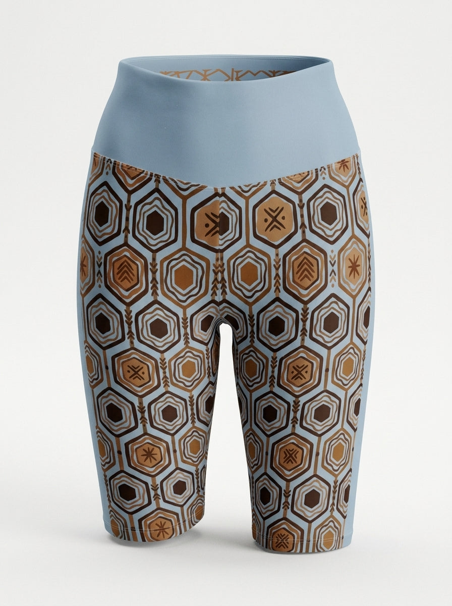AnanseNova™ Biker Shorts in Igwe Blue, ghost mannequin front view showing the hexagon print and high waistband — SunBorn