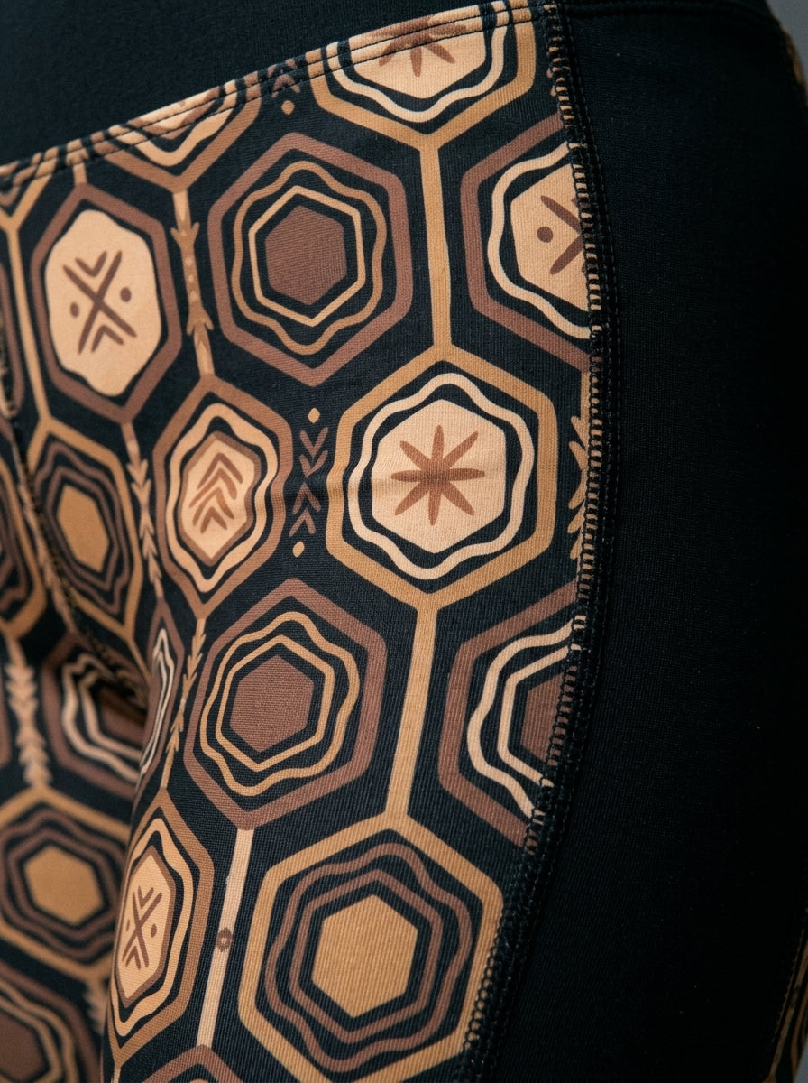 Close-up of the Oji Black hexagon web-cell print and side panel seam on the AnanseNova™ Biker Shorts — SunBorn