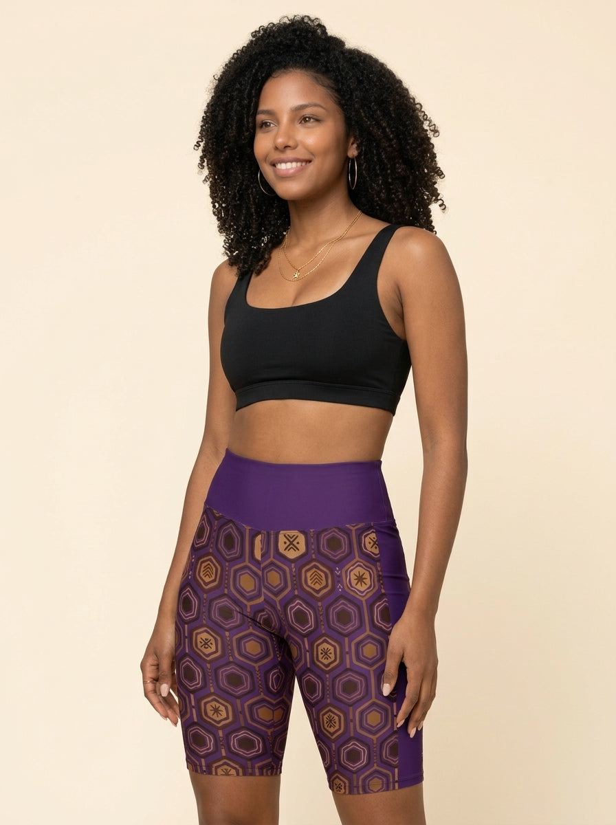 AnanseNova™ Biker Shorts in Ugo Purple styled with a black sports bra, studio portrait — SunBorn