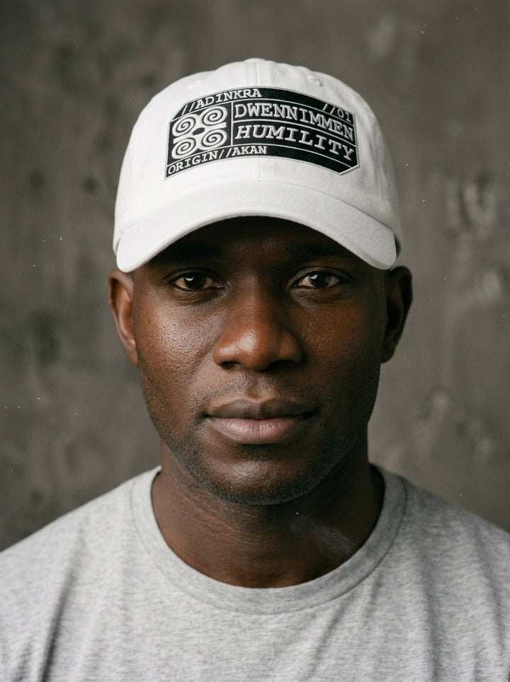 Adinkra Humility Dad Hat in Ocha White — worn front view, embroidered Dwennimmen badge