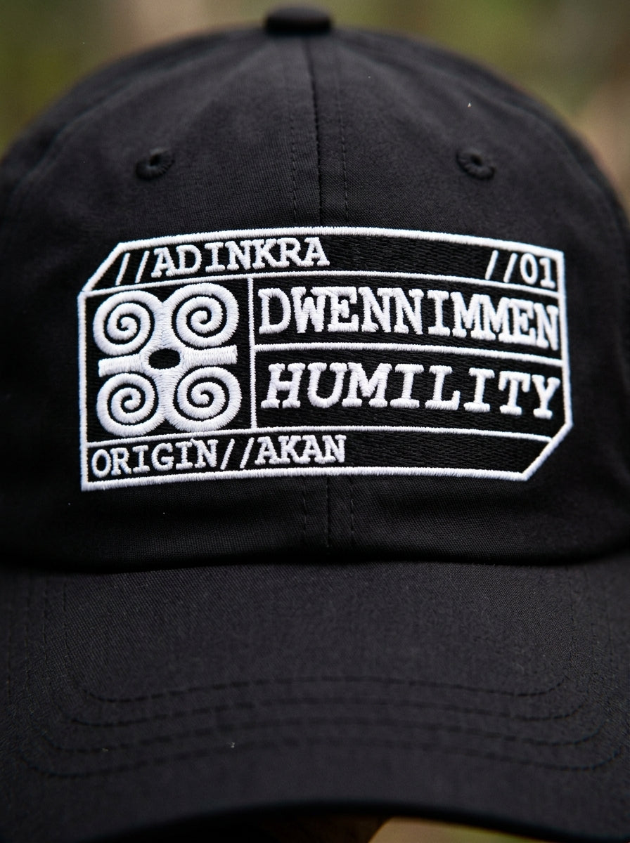 Adinkra Humility Dad Hat in Oji Black — macro detail of embroidered Dwennimmen glyph badge