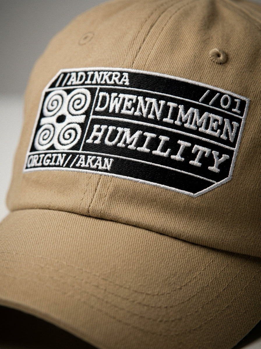 Adinkra Humility Dad Hat in Aja Sand — macro detail of embroidered Dwennimmen glyph badge
