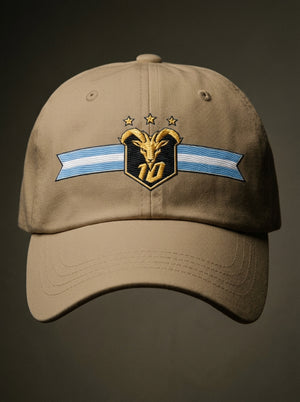GOAT Celeste Dad Hat in Aja Sand, front view — gold goat crest with N°10 and three stars on an Albiceleste ribbon.