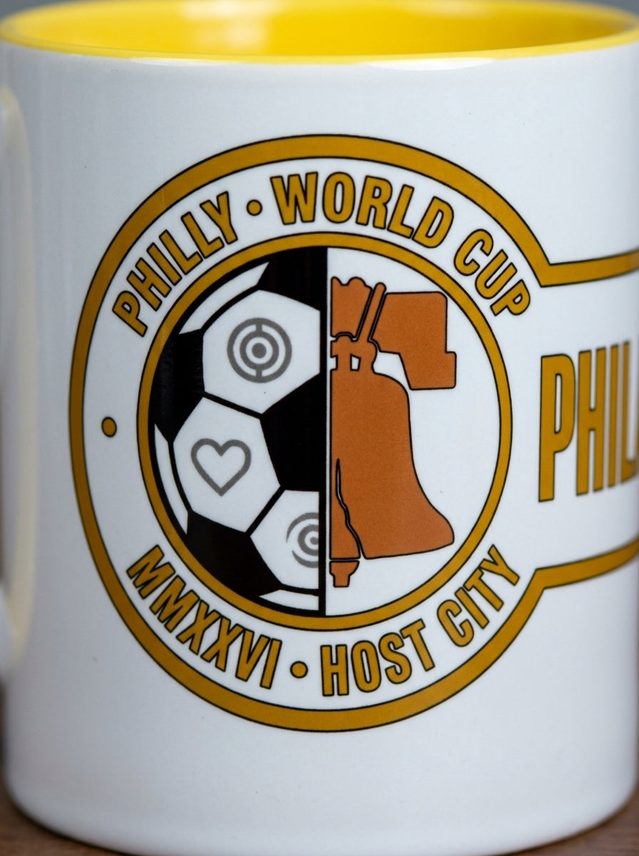 Liberty Protocol Philly '26 Mug — close-up of the Liberty Bell and soccer ball crest with Yellow interior visible