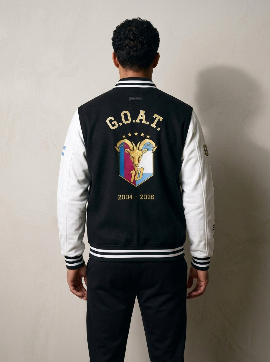 Back of the GOAT // Fusión Letterman Jacket in Jet Black/Arctic White — arched G.O.A.T. over the full-colour crest, 2004–2026