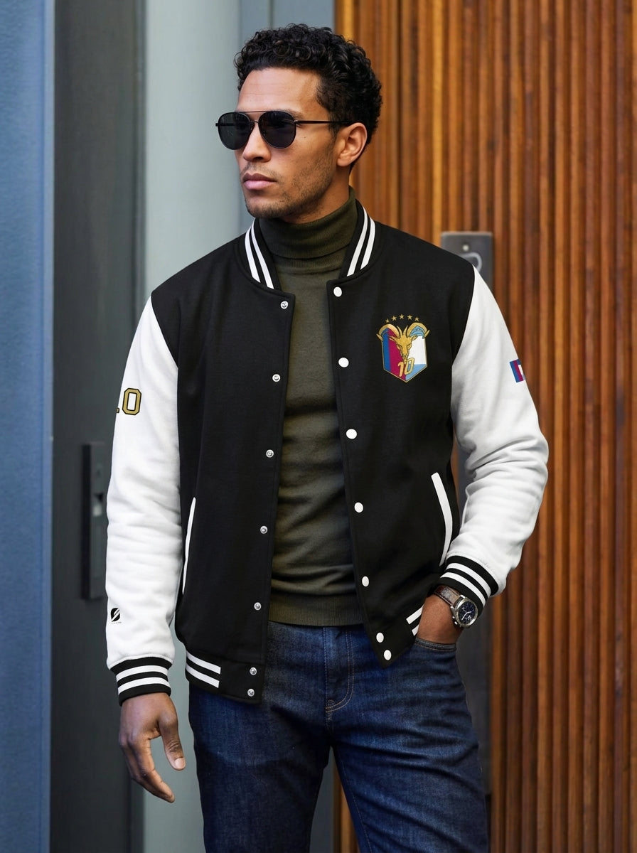 GOAT // Fusión Letterman Jacket in Jet Black/Arctic White — lifestyle shot, both-flags crest on AkomaDrive™ varsity
