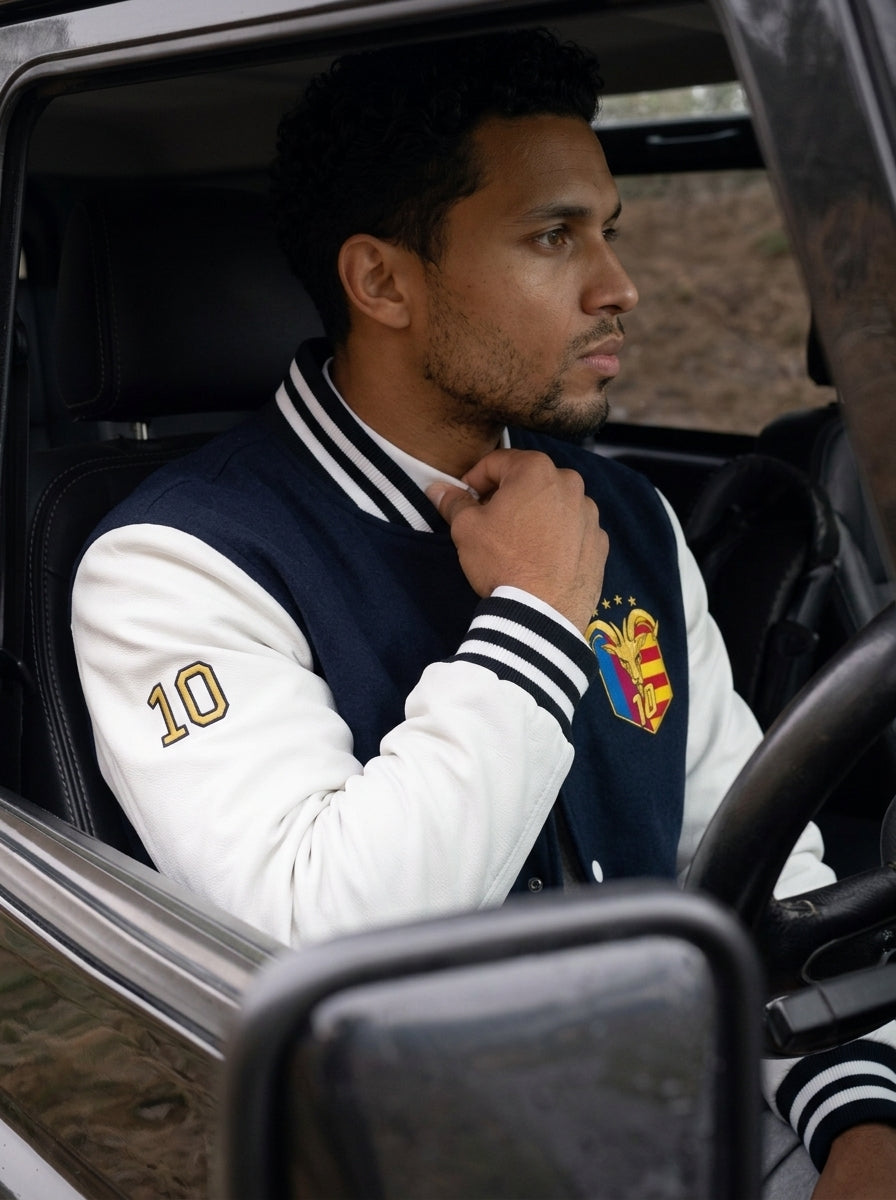 Model wearing the GOAT // Catalan Letterman Jacket in oxford navy, editorial lifestyle shot.