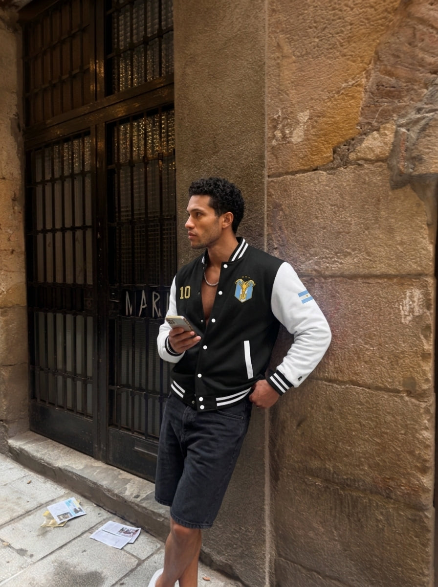 Lifestyle shot — GOAT // Celeste Letterman Jacket in Jet Black / Arctic White, worn on the street.