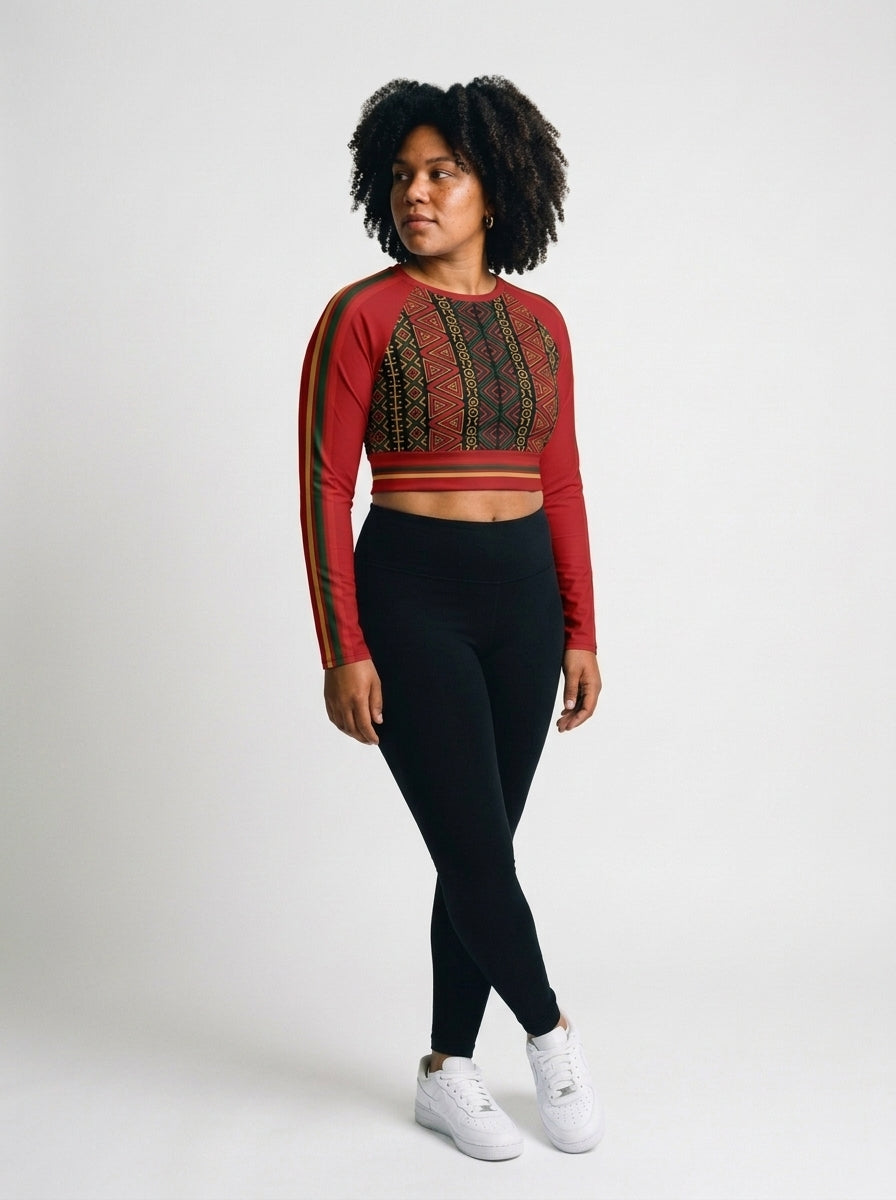 N'Donso™ Long Sleeve Crop in Uhie Red, three-quarter left — the Hunter's Road print in red on black climbing the raglan sleeves, cropped to a wide waistband