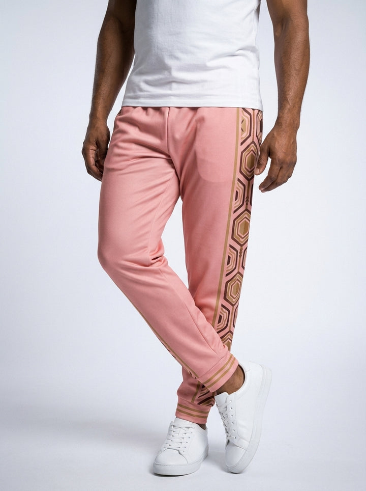 AnanseNova™ Men's Joggers in Eze Pink, front view on model — AnanseNova™ hexagon side-panel stripe edged in bronze pinstripes, striped ribbed ankle cuffs. SunBorn