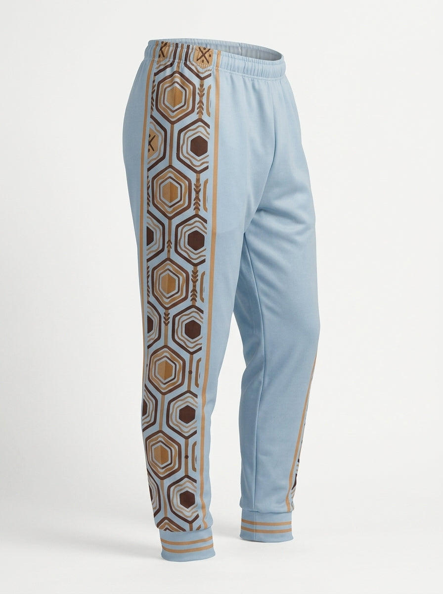 AnanseNova™ Men's Joggers in Igwe Blue, ghost mannequin three-quarter left view — hexagon side panel and bronze pinstripe. SunBorn