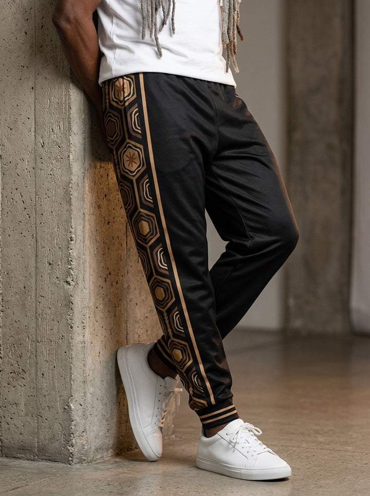 AnanseNova™ Men's Joggers in Oji Black, front view on model — AnanseNova™ hexagon side-panel stripe edged in bronze pinstripes, striped ribbed ankle cuffs. SunBorn