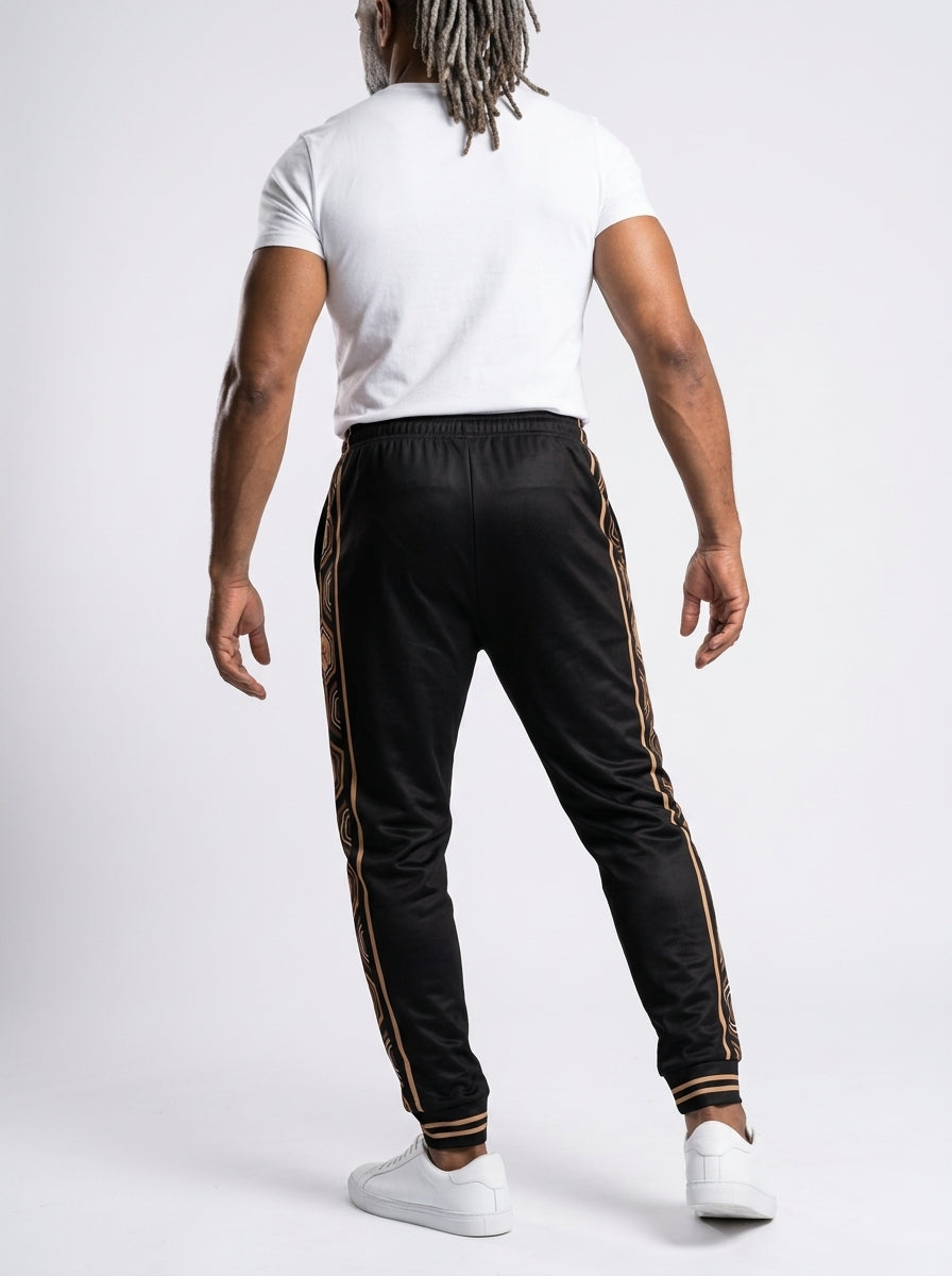AnanseNova™ Men's Joggers in Oji Black, back view on model — hexagon side panels running waist to cuff, slim athletic fit. SunBorn