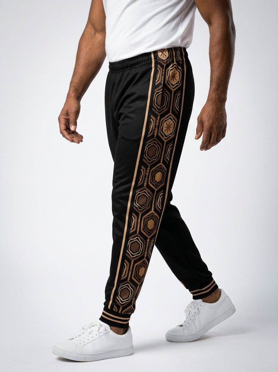 AnanseNova™ Men's Joggers in Oji Black, three-quarter left view on model — hexagon web-cell side panel with bronze pinstripe. SunBorn