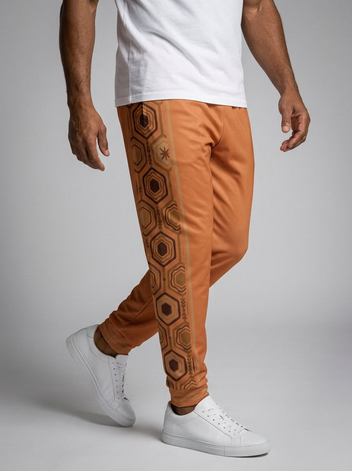 AnanseNova™ Men's Joggers in Sango Orange, front view on model — AnanseNova™ hexagon side-panel stripe edged in bronze pinstripes, striped ribbed ankle cuffs. SunBorn