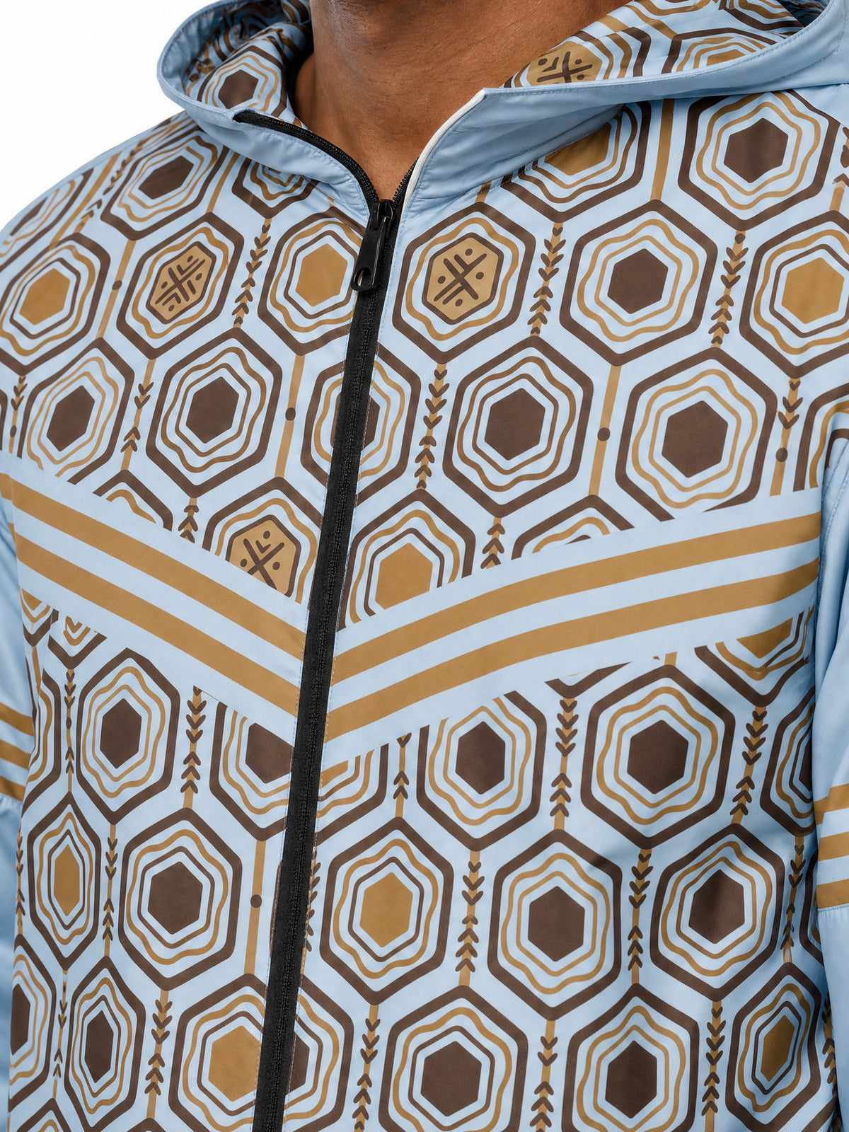 AnanseNova™ Men's Windbreaker in Igwe Blue — close-up of the bronze chevron, zipper and hexagon print on the MframaShell™ water-resistant shell