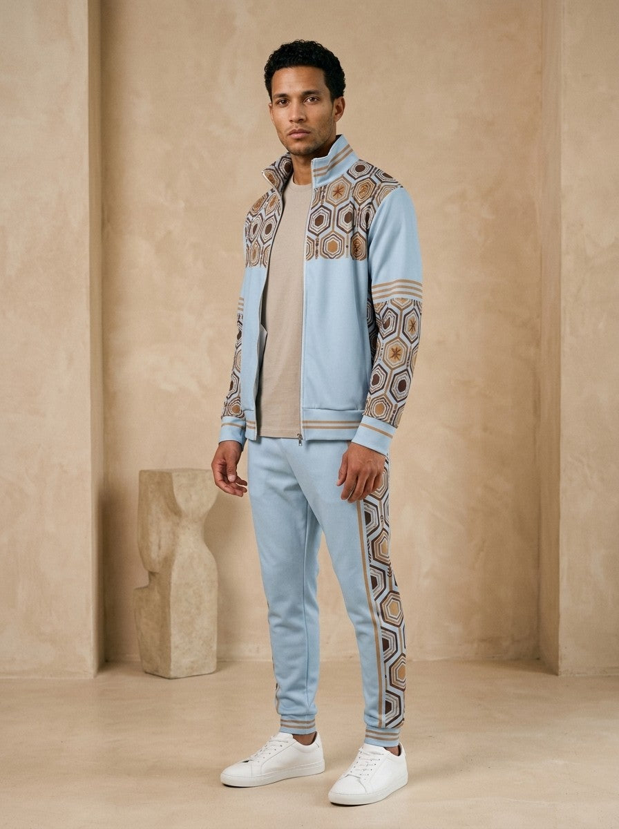 AnanseNova™ Track Jacket + Joggers Set in Igwe Blue, three-quarter left view on model showing the printed sleeve and jogger side panel