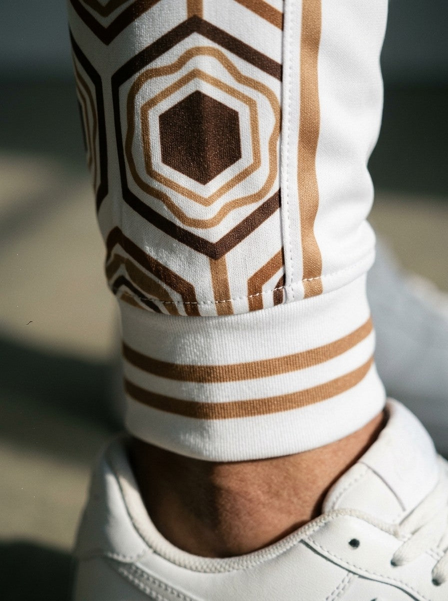 Close-up of the AnanseNova™ Joggers cuff in Ocha White: striped ribbed cuff and the brown and gold hexagon side stripe