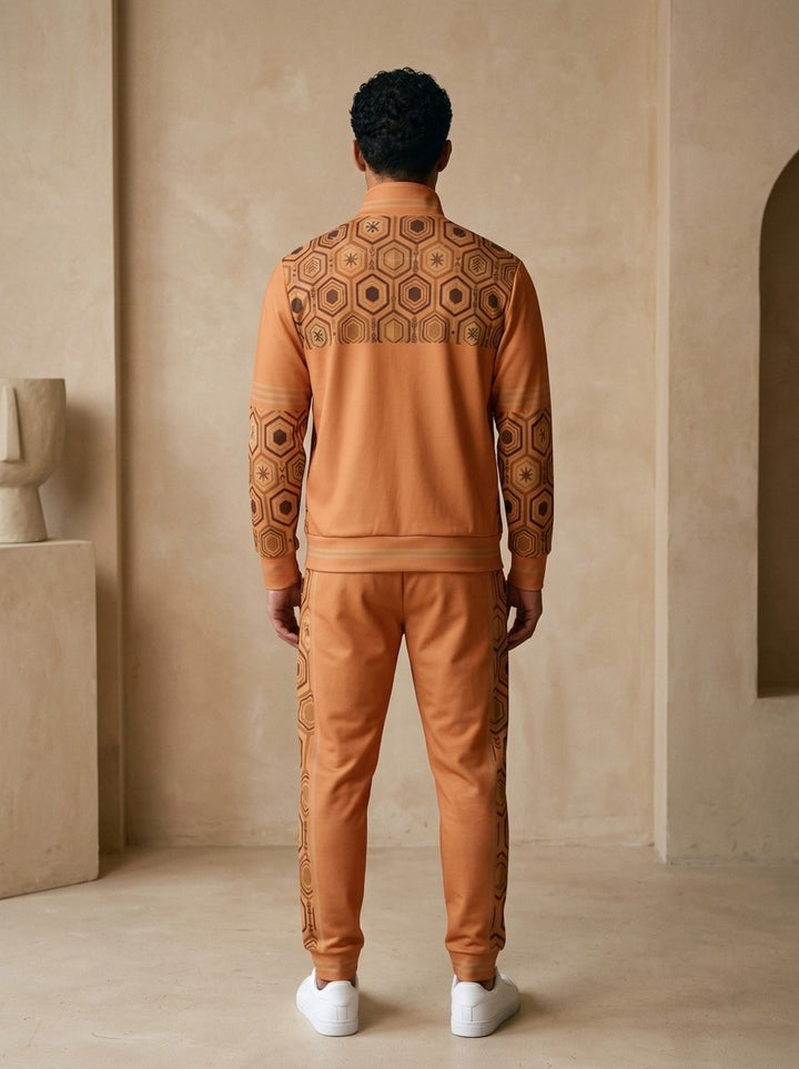 AnanseNova™ Track Jacket + Joggers Set in Sango Orange, back view on model showing the hexagon print yoke, printed sleeves and jogger side stripes
