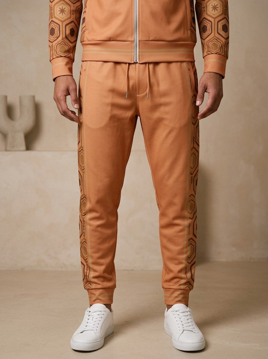 AnanseNova™ Joggers in Sango Orange on model, waist to sneakers: drawcord waistband, tapered leg, striped cuffs and the hexagon side stripes