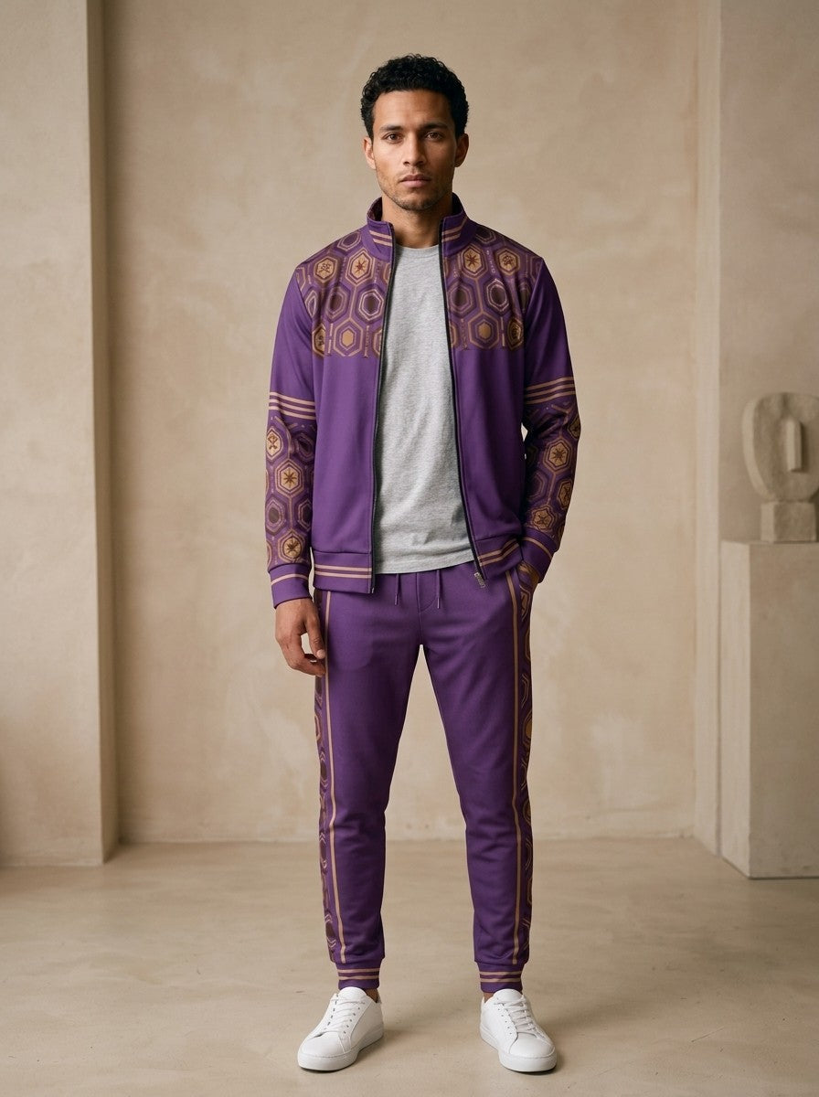 AnanseNova™ Track Jacket + Joggers Set in Ugo Purple, front view on model: purple track jacket with brown and gold hexagon print yoke and sleeves, gold sleeve stripes, matching joggers with hex side stripes