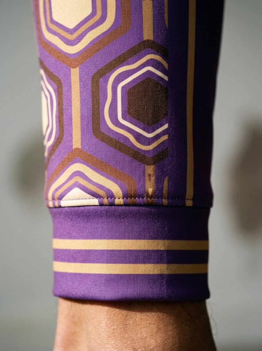 Close-up of the AnanseNova™ Joggers cuff in Ugo Purple: striped ribbed cuff and the brown and gold hexagon side stripe