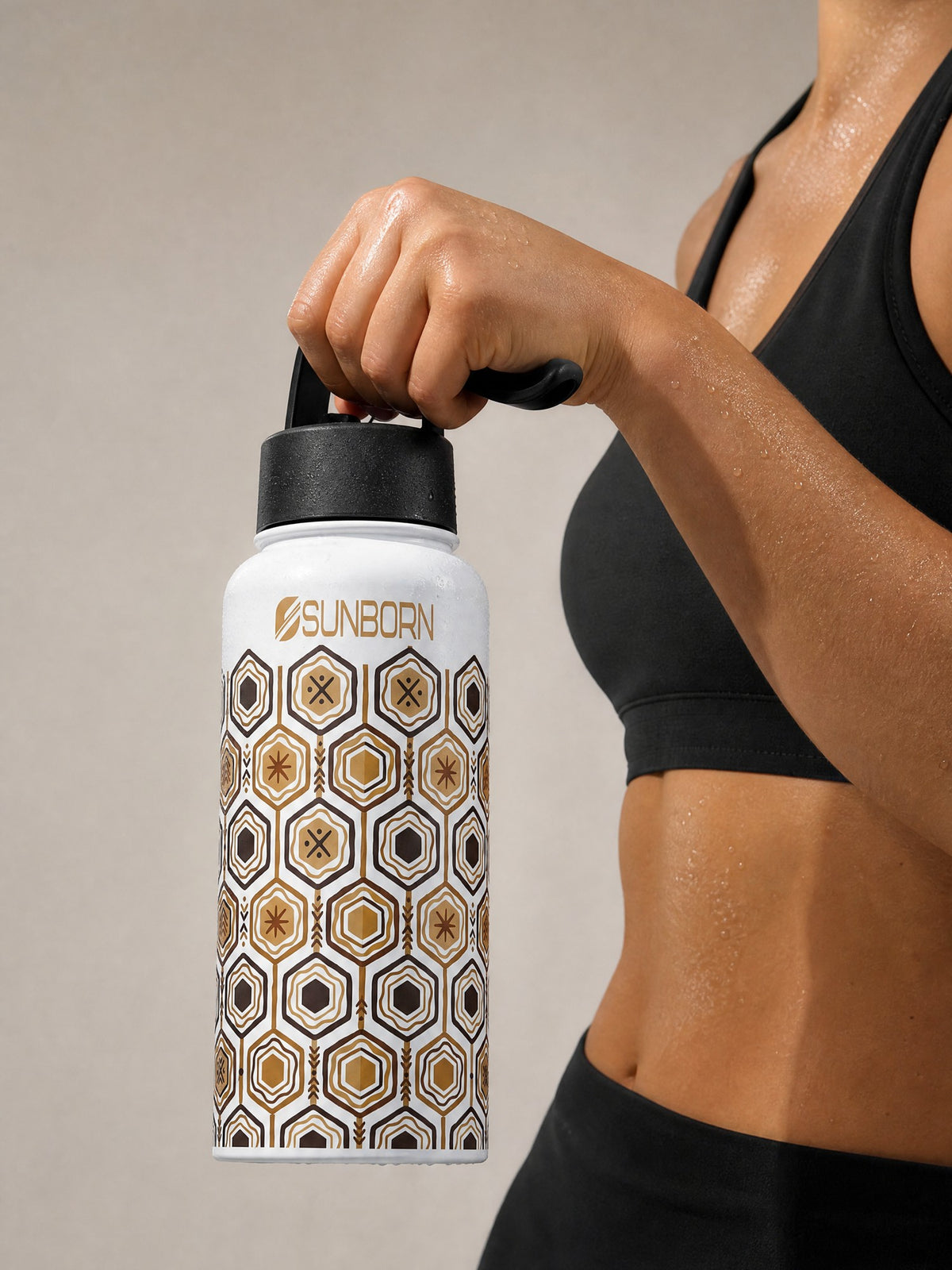 AnanseNova™ Water Bottle held by its lid handle mid-workout, showing 32 oz scale