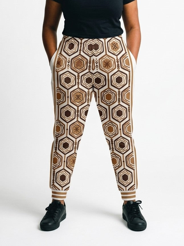 AnanseNova™ Women's Joggers in Ocha White, front view on model, full-front bronze and brown hexagon print with white side panels, bronze side stripes and striped cuffs | SunBorn