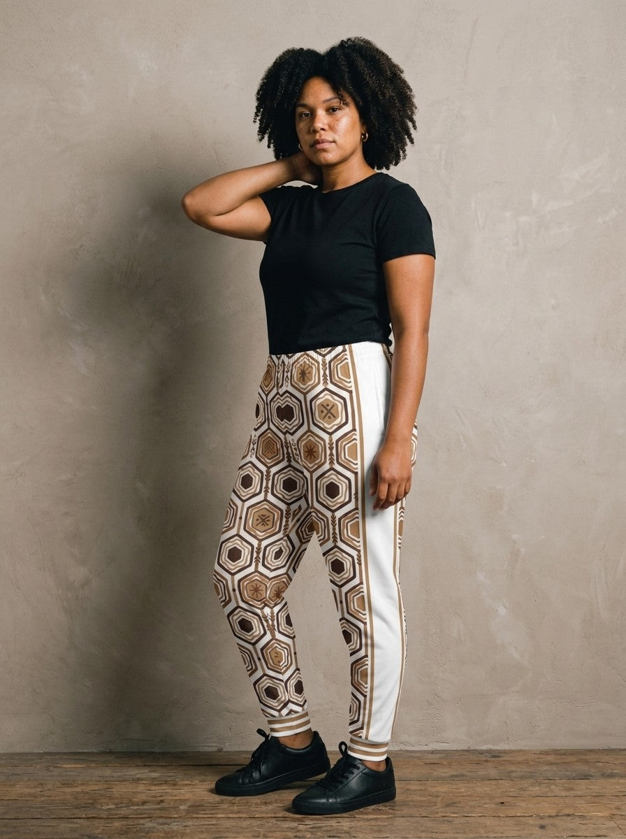 Three-quarter view of AnanseNova™ Women's Joggers in Ocha White showing the white side panel and bronze side stripe, styled with a black tee