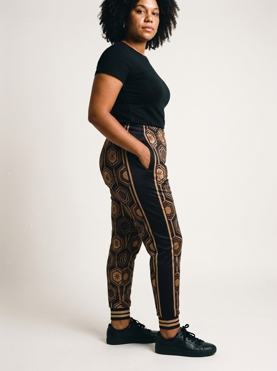 Three-quarter side view of AnanseNova™ Women's Joggers in Oji Black on model, black side panel, pocket and bronze side stripes
