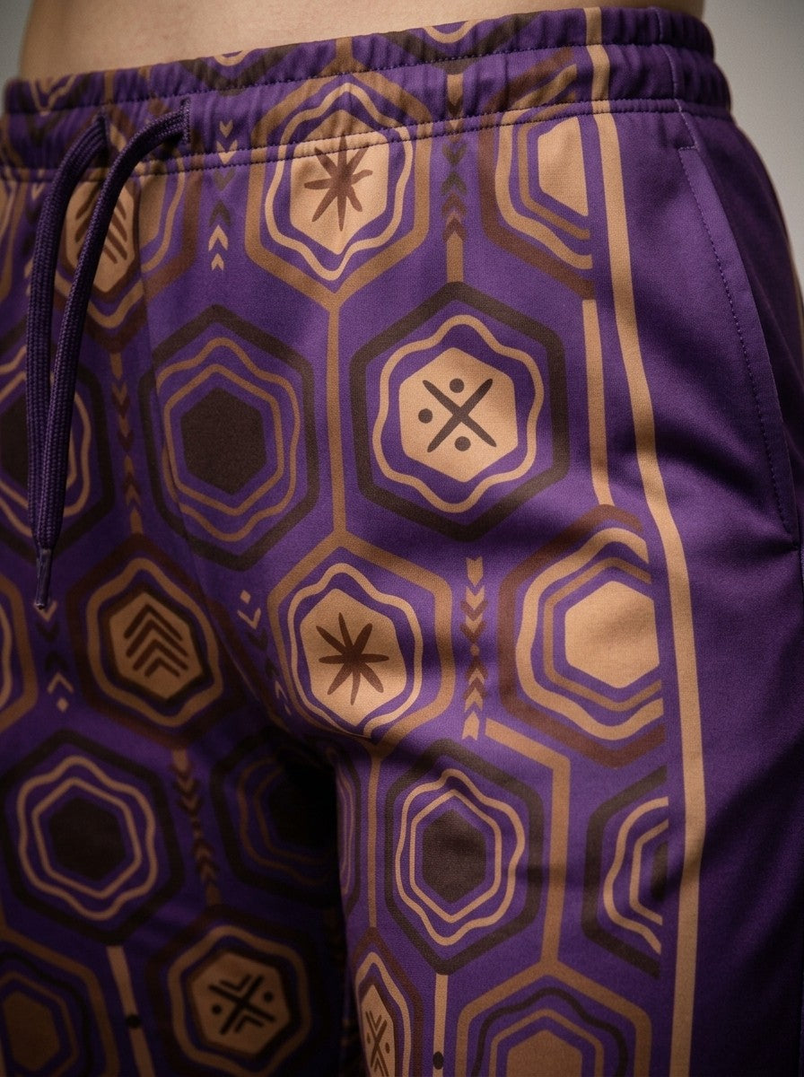 Close-up of the sublimation-printed AnanseNova™ hexagon pattern, drawcord and bronze side stripe on Ugo Purple women's joggers