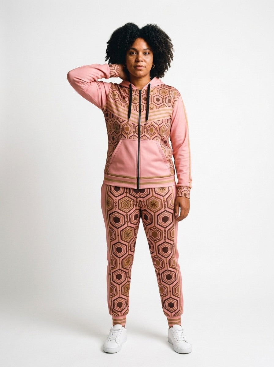 Women's tracksuit set in Adaeze Pink: AnanseNova™ Zip Hoodie + Joggers on model, front view, bronze hexagon print with chevron chest stripes and full-leg jogger print | SunBorn