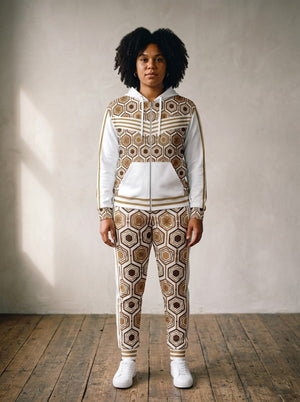 Women's tracksuit set in Ocha White: AnanseNova™ Zip Hoodie + Joggers on model, front view, bronze hexagon print with chevron chest stripes and full-leg jogger print | SunBorn