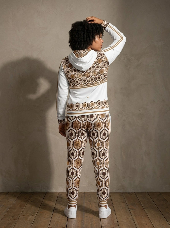 Back view of the AnanseNova™ women's Zip Hoodie + Joggers set in Ocha White on model, hexagon back yoke, bronze sleeve stripes and printed joggers | SunBorn
