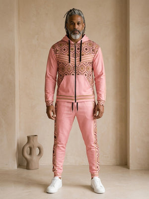 AnanseNova™ Zip Hoodie + Joggers Set in Eze Pink, front view on model: pink zip hoodie with brown and gold hexagon print panels and gold sleeve stripes, matching pink joggers with hex side stripes
