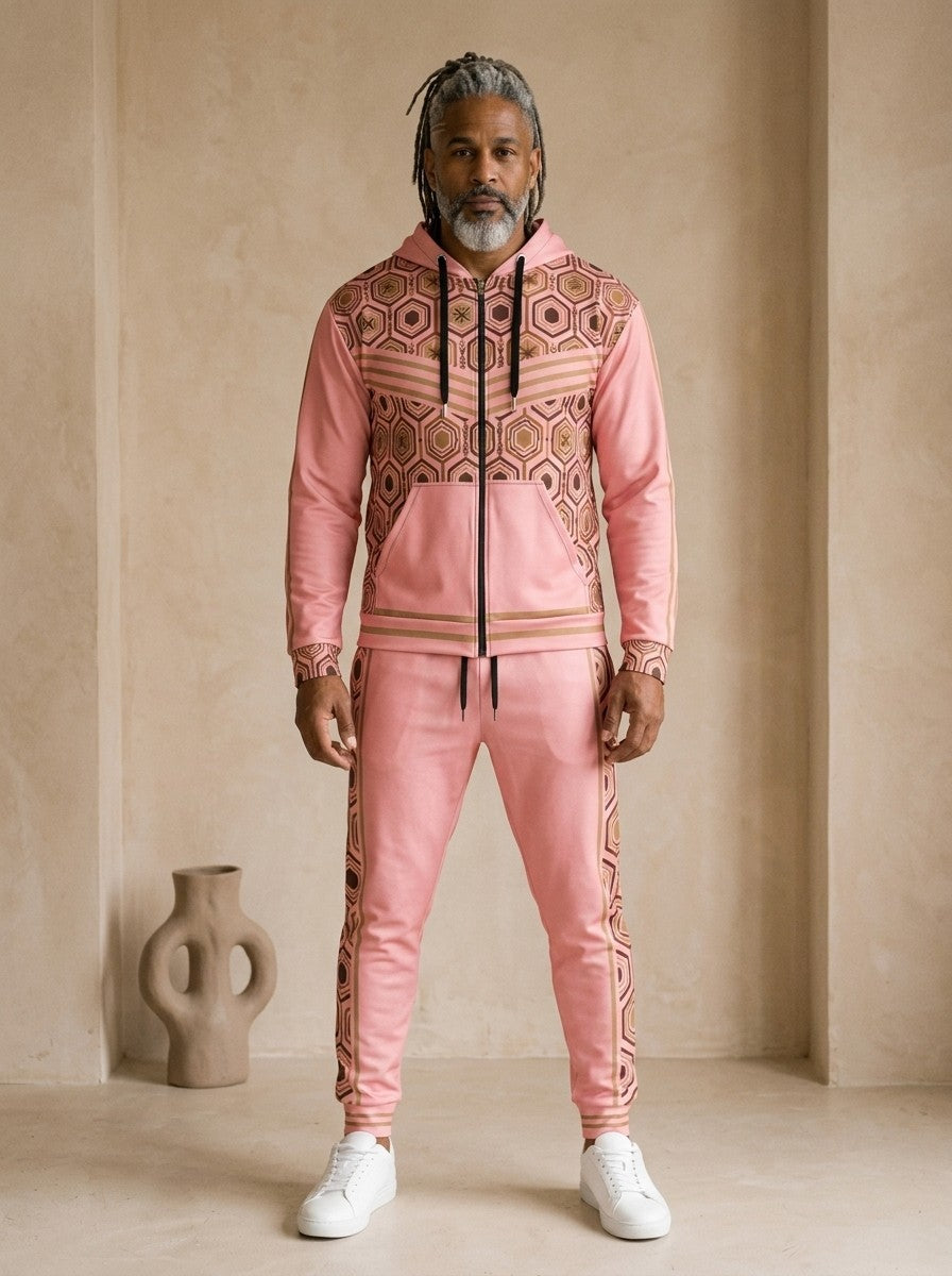 AnanseNova™ Zip Hoodie + Joggers Set in Eze Pink, front view on model: pink zip hoodie with brown and gold hexagon print panels and gold sleeve stripes, matching pink joggers with hex side stripes