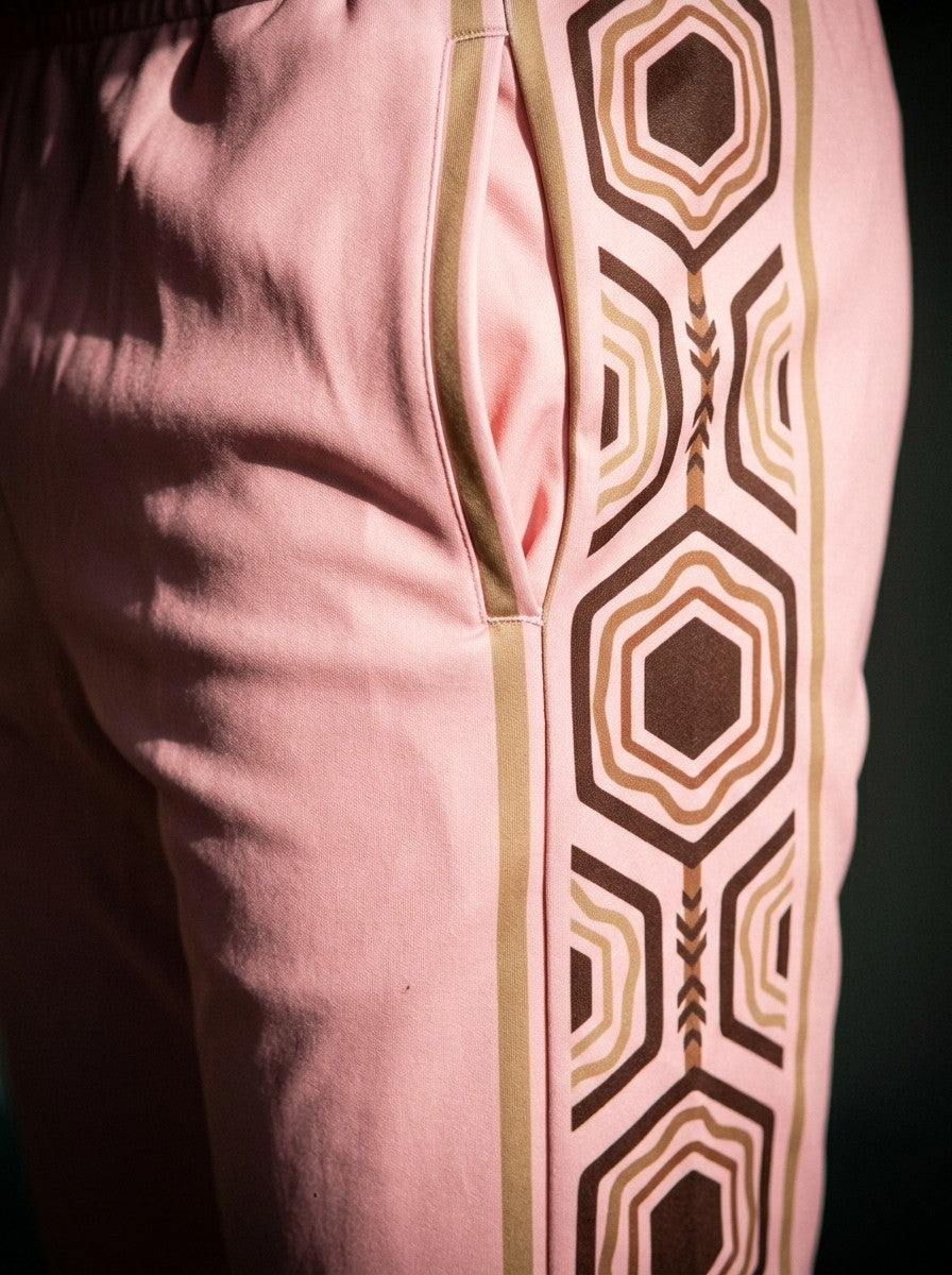 Close-up of the AnanseNova™ Joggers in Eze Pink: side pocket and the brown and gold hexagon side stripe