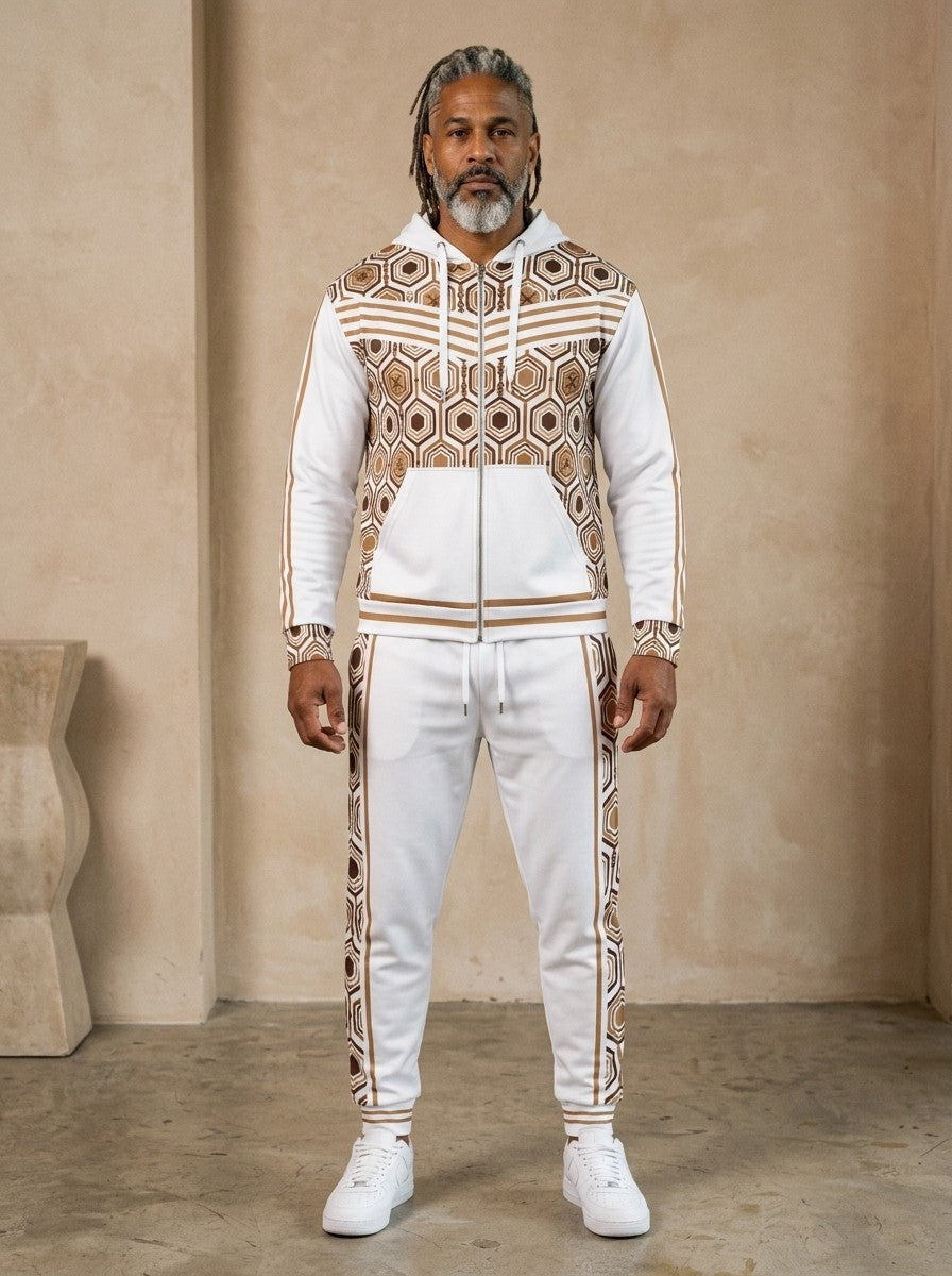 AnanseNova™ Zip Hoodie + Joggers Set in Ocha White, front view on model: white zip hoodie with brown and gold hexagon print panels and gold sleeve stripes, matching white joggers with hex side stripes