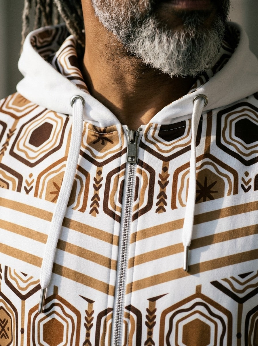Close-up of the AnanseNova™ Zip Hoodie in Ocha White: printed hood lining, drawcords, metal zip and the hexagon and stripe chest print