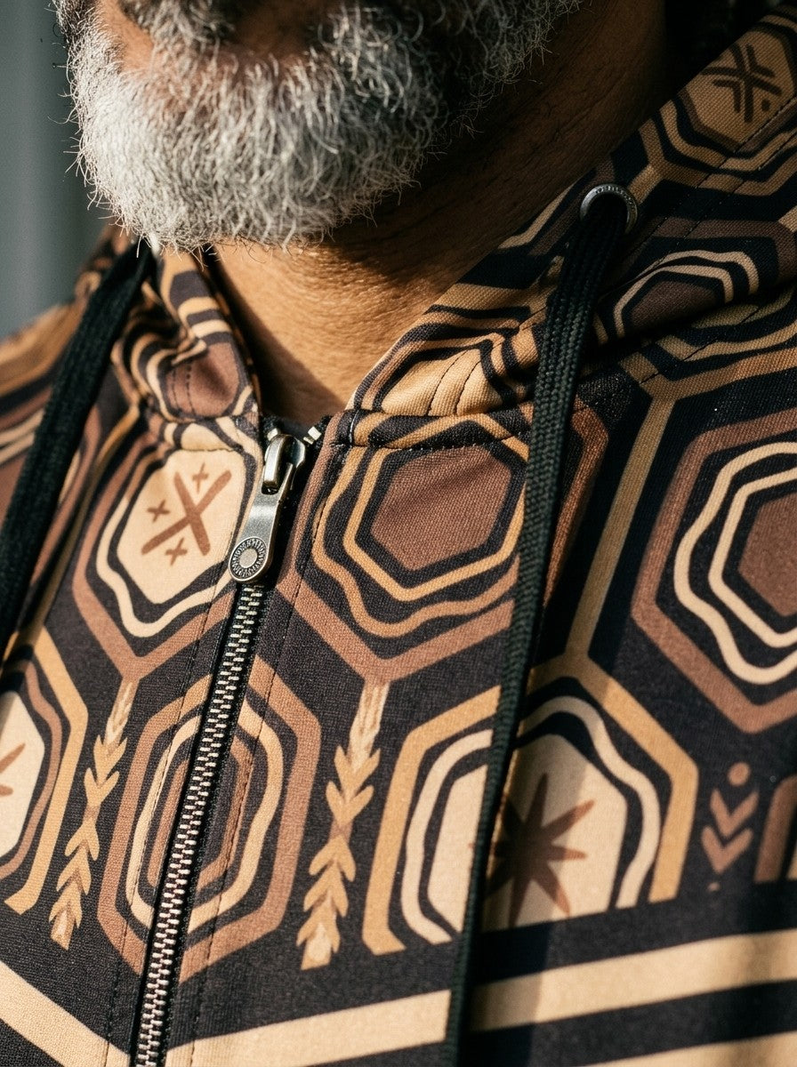 Close-up of the AnanseNova™ Zip Hoodie in Oji Black: printed hood lining, drawcords, metal zip and the hexagon and stripe chest print