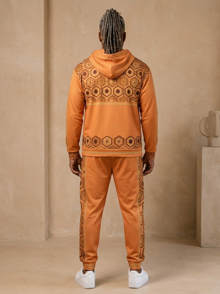 AnanseNova™ Zip Hoodie + Joggers Set in Sango Orange, back view on model showing the hexagon print yoke and hem band and the joggers' side stripes