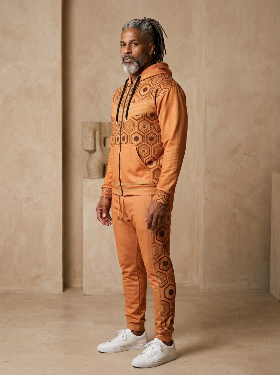 AnanseNova™ Zip Hoodie + Joggers Set in Sango Orange, three-quarter view on model showing the sleeve stripes and jogger side panel
