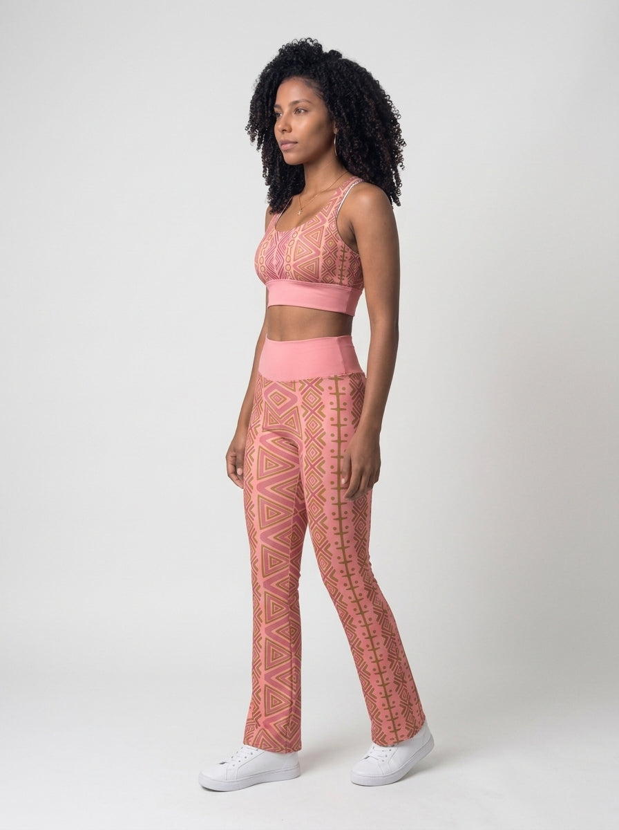 Three-quarter left view of the N'Donso™ Bra + Flare Leggings Set in Adaeze Pink