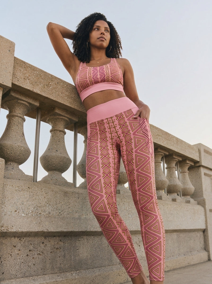 Woman leaning on a stone balustrade in the N'Donso™ Bra + Pocket Leggings Set in Adaeze Pink, hand in the side pocket