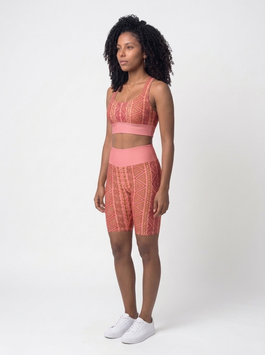Three-quarter left view of the N'Donso™ Bra + Biker Shorts Set in Adaeze Pink