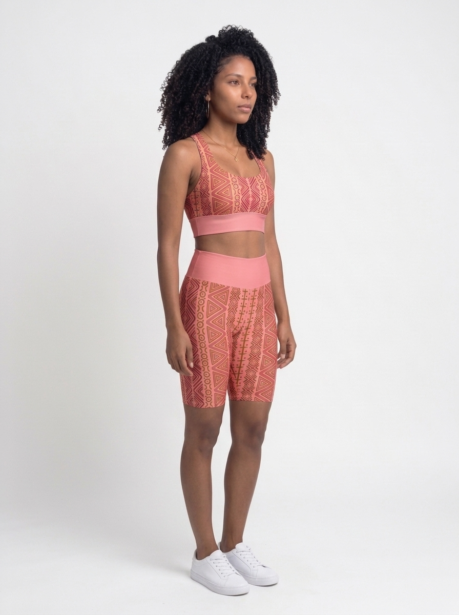 Three-quarter right view of the N'Donso™ Bra + Biker Shorts Set in Adaeze Pink