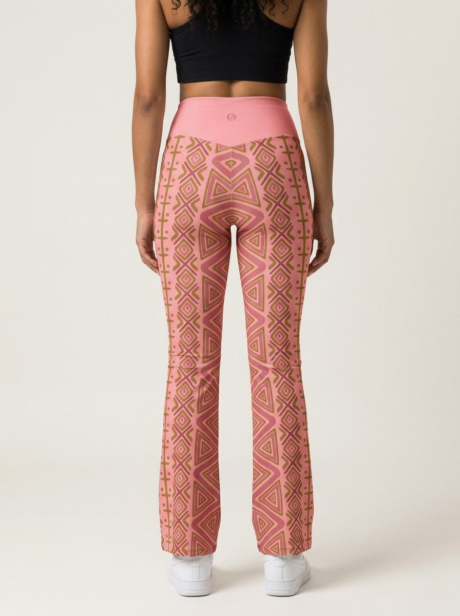Back view of SunBorn N'Donso™ Flare Leggings in Adaeze Pink on model: V-back waistband with SunBorn mark and mirrored zigzag print