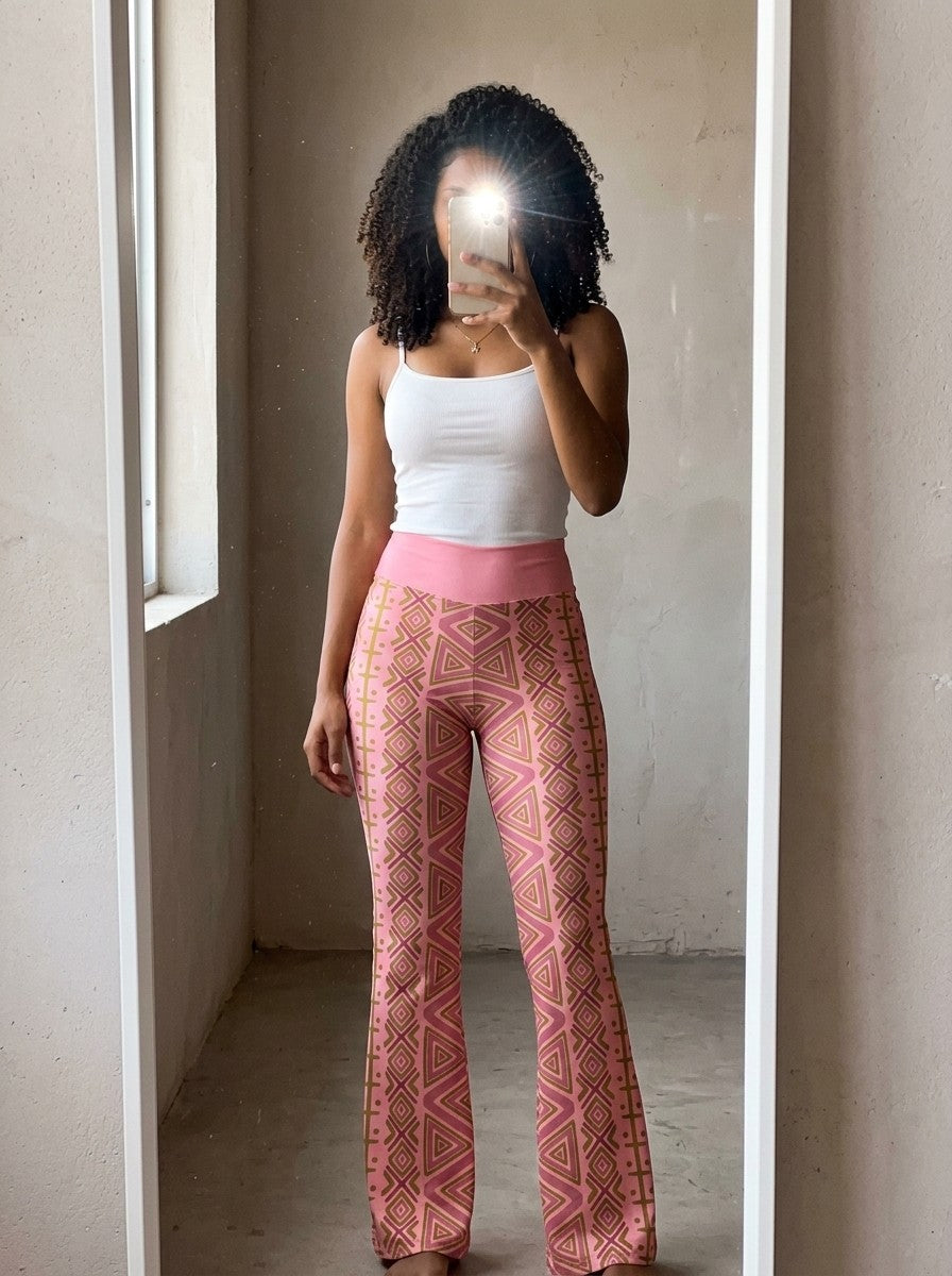 Mirror selfie wearing SunBorn N'Donso™ Flare Leggings in Adaeze Pink with a white tank